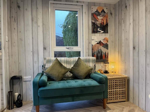 Sofa beneath a window, with soft lighting and cushions